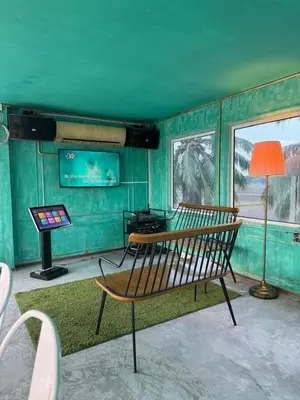 a room with a bench and a table and a lamp at PadiBox Homestay in Sekincan