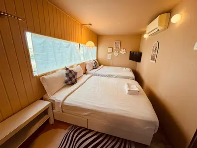 two beds in a small room with a window at PadiBox Homestay in Sekincan