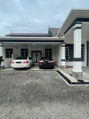 two cars parked in front of a house at Homestay Selesa KPP Guest House in Gua Sai
