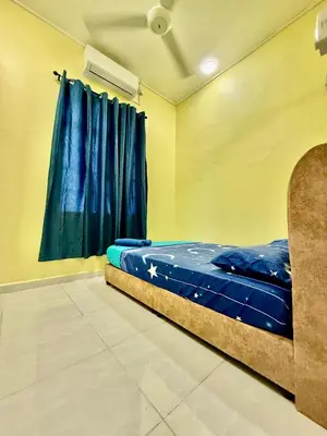 a bed in a room with a blue curtain at Homestay Selesa KPP Guest House in Gua Sai