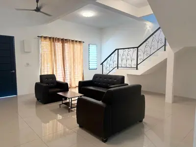 a living room with two couches and a staircase at Classic Home Stay in Kuala Ketil