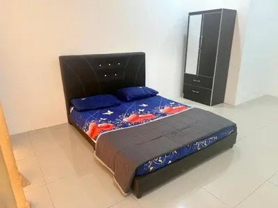 a bedroom with a bed and a dresser in a room at Classic Home Stay in Kuala Ketil