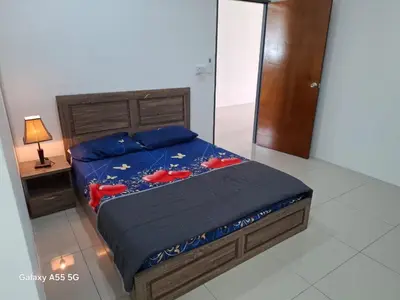 a bedroom with a bed with red shoes on it at Classic Home Stay in Kuala Ketil