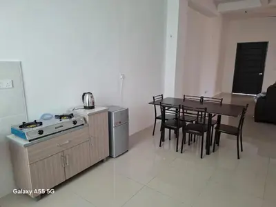 a kitchen and dining room with a table and a stove at Classic Home Stay in Kuala Ketil