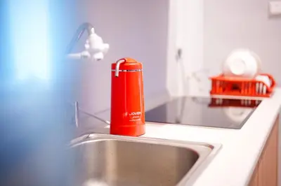 a red bottle sitting on top of a kitchen sink at Mahkota Valley Suites Kuantan by Iconique in Gua Sai