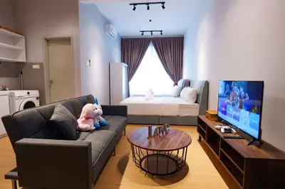 a living room with a couch and a tv at Mahkota Valley Suites Kuantan by Iconique in Gua Sai