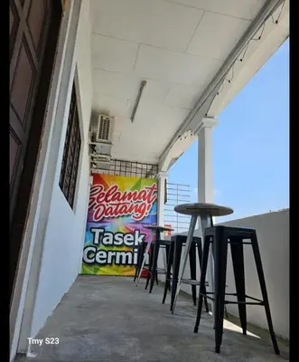 a row of tables and stools on a patio at Tasek Cermin Roomstay in Ipoh