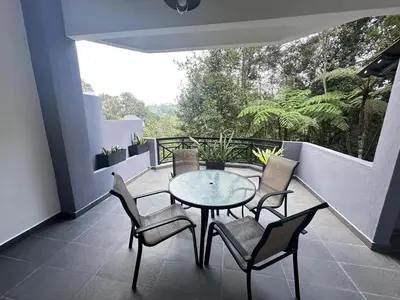 a patio with a table and chairs on a balcony at Fraser's Haven SilverparkResort Walk down 8 steps in Bukit Fraser