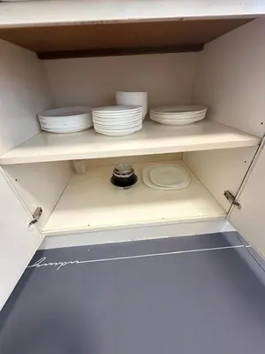 a shelf with plates and bowls on it at Fraser's Haven SilverparkResort Walk down 8 steps in Bukit Fraser