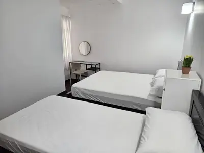 a room with two beds and a table with a mirror at Fraser's Haven SilverparkResort Walk down 8 steps in Bukit Fraser