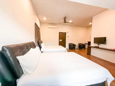 a hotel room with two beds and a flat screen tv at ComfortCottage Ipoh Coliving & Whole Unit in Ipoh