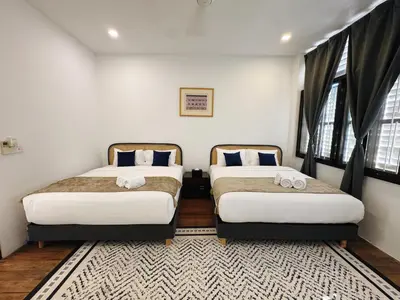 two beds sitting in a room with windows at Courtyard by Heritage Row in George Town