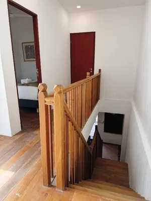 a hallway with a wooden staircase with a mirror at Courtyard by Heritage Row in George Town