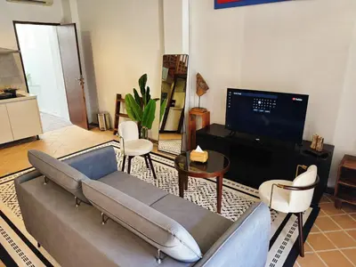 a living room with a couch and a tv at Courtyard by Heritage Row in George Town