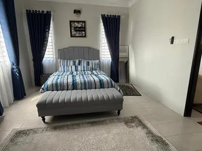 a bedroom with a bed in a room with blue curtains at Villa SRC in Sungai Petani