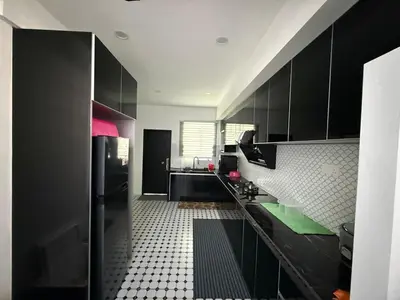 a kitchen with black cabinets and a tile floor at Villa SRC in Sungai Petani