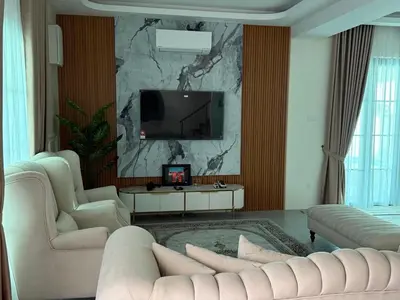 a living room with a couch and a tv on a wall at Villa SRC in Sungai Petani