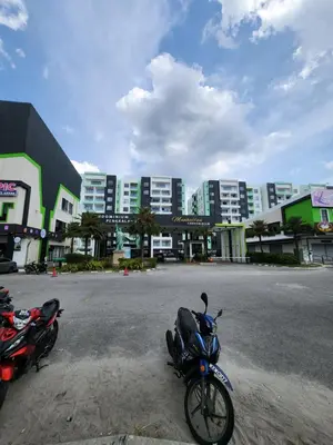 two motorcycles parked in a parking lot in front of buildings at Manhattan Condominium Ipoh in Ipoh