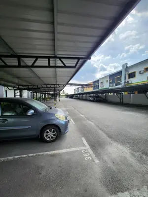 a blue car parked under a building next to a train at Manhattan Condominium Ipoh in Ipoh
