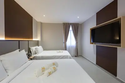 a hotel room with two beds and a flat screen tv at M Spice Hotel Seberang Jaya in Perai