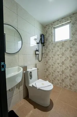 a bathroom with a toilet and a sink and a mirror at M Spice Hotel Seberang Jaya in Perai