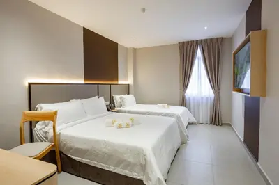 a hotel room with two beds and a window at M Spice Hotel Seberang Jaya in Perai
