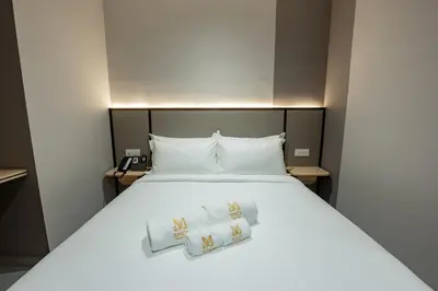 a bedroom with a white bed with two pillows at M Spice Hotel Seberang Jaya in Perai