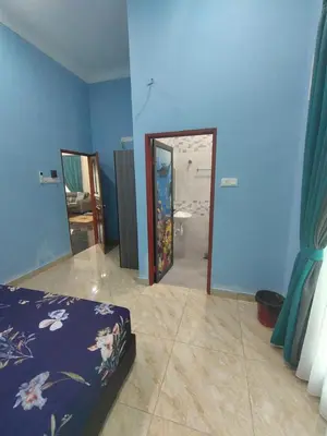 a blue room with a bed and a mirror at SUN HOMESTAY Teluk Intan