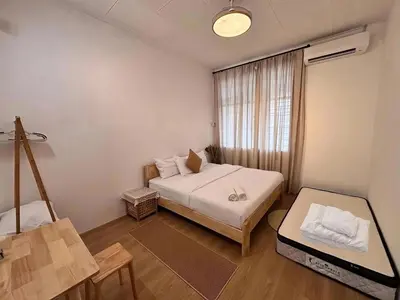 a small room with a bed and a table at Corner Single-Storey Fire Camp 9pax FreeWiFi Ipoh Town By LUX SUITES in Ipoh