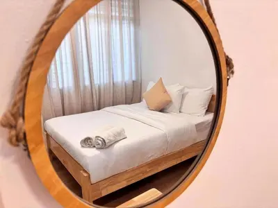 a bedroom with a bed in a mirror at Corner Single-Storey Fire Camp 9pax FreeWiFi Ipoh Town By LUX SUITES in Ipoh