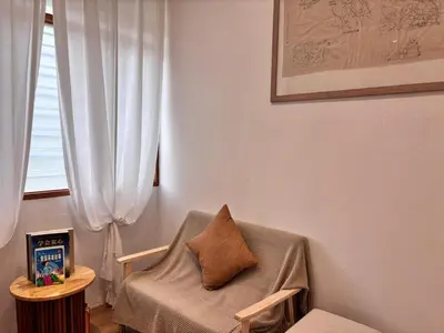 a living room with a chair and a window at Corner Single-Storey Fire Camp 9pax FreeWiFi Ipoh Town By LUX SUITES in Ipoh