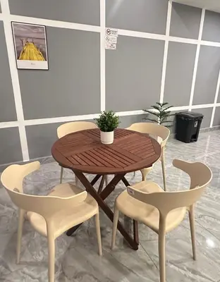 a wooden table and chairs with a potted plant on it at C&CDreamland hotel in Ipoh