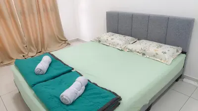 two beds in a room with towels and pillows at Horizon Skyline Loft in Ipoh