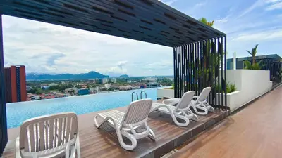 a group of chairs sitting on a deck next to a pool at Horizon Skyline Loft in Ipoh