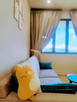 a stuffed animal sitting on a couch in a room at Luxury Sky Stay Sea & Penang Bridge View in Bayan Lepas