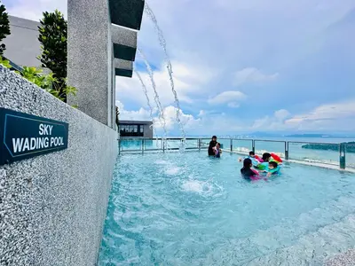 a group of people playing in a swimming pool at High Floor Sea View Penang Bridge Luxury 2BR in Bayan Lepas