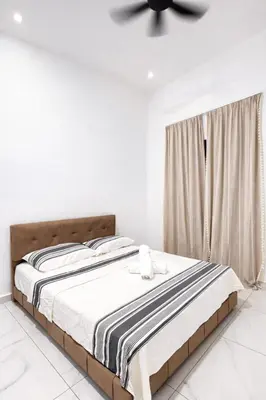 a bedroom with a bed with a ceiling fan at Villa Natura ByTheNook in Sungai Petani