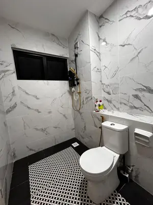 a white bathroom with a toilet and a window at Villa Natura ByTheNook in Sungai Petani