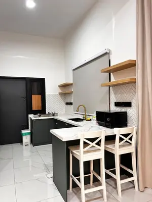 a kitchen with a table and two stools in it at Villa Natura ByTheNook in Sungai Petani