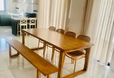 a wooden dining table with chairs and a bench at Villa Natura ByTheNook in Sungai Petani