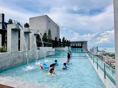a group of children playing in a swimming pool at Luxury 2BR Rooftop Infinity Pool 8 Pax airport usm in Bayan Lepas