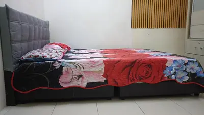 a bed with a quilt on it in a room at Homestay Kak Su Seri Iskandar in Seri Iskandar