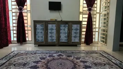 a living room with a cabinet and a rug at Homestay Kak Su Seri Iskandar in Seri Iskandar