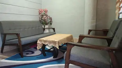 a living room with two chairs and a table at Homestay Kak Su Seri Iskandar in Seri Iskandar