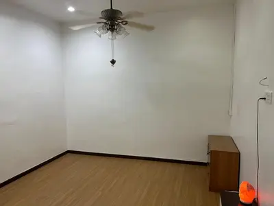 a room with a white wall and a ceiling fan at LIY Homestay in Gua Sai