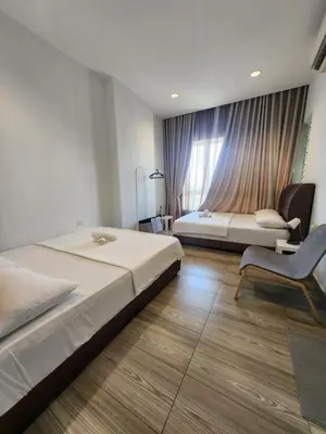 a bedroom with a bed and a chair and a window at The Octagon Ipoh - City Centre Premium Stay in Ipoh