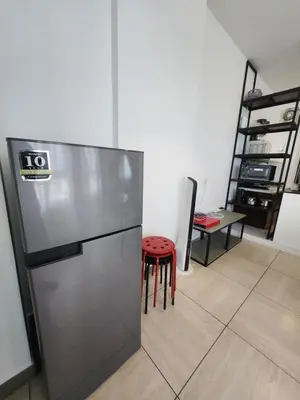 a kitchen with a refrigerator and a red stool at The Octagon Ipoh - City Centre Premium Stay in Ipoh