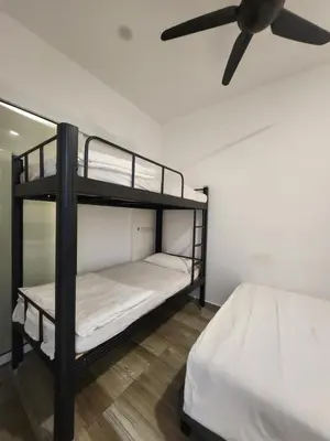 a bedroom with two bunk beds and a ceiling fan at The Octagon Ipoh - City Centre Premium Stay in Ipoh