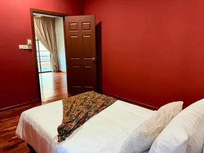 a bedroom with red walls and a bed with a blanket at Sunway Lakeside Villa Ipoh in Tambun