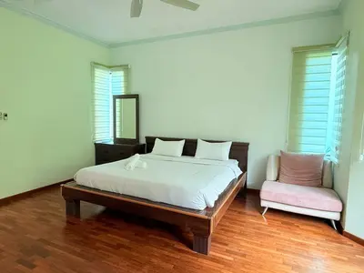 a bedroom with a bed and a chair in it at Sunway Lakeside Villa Ipoh in Tambun